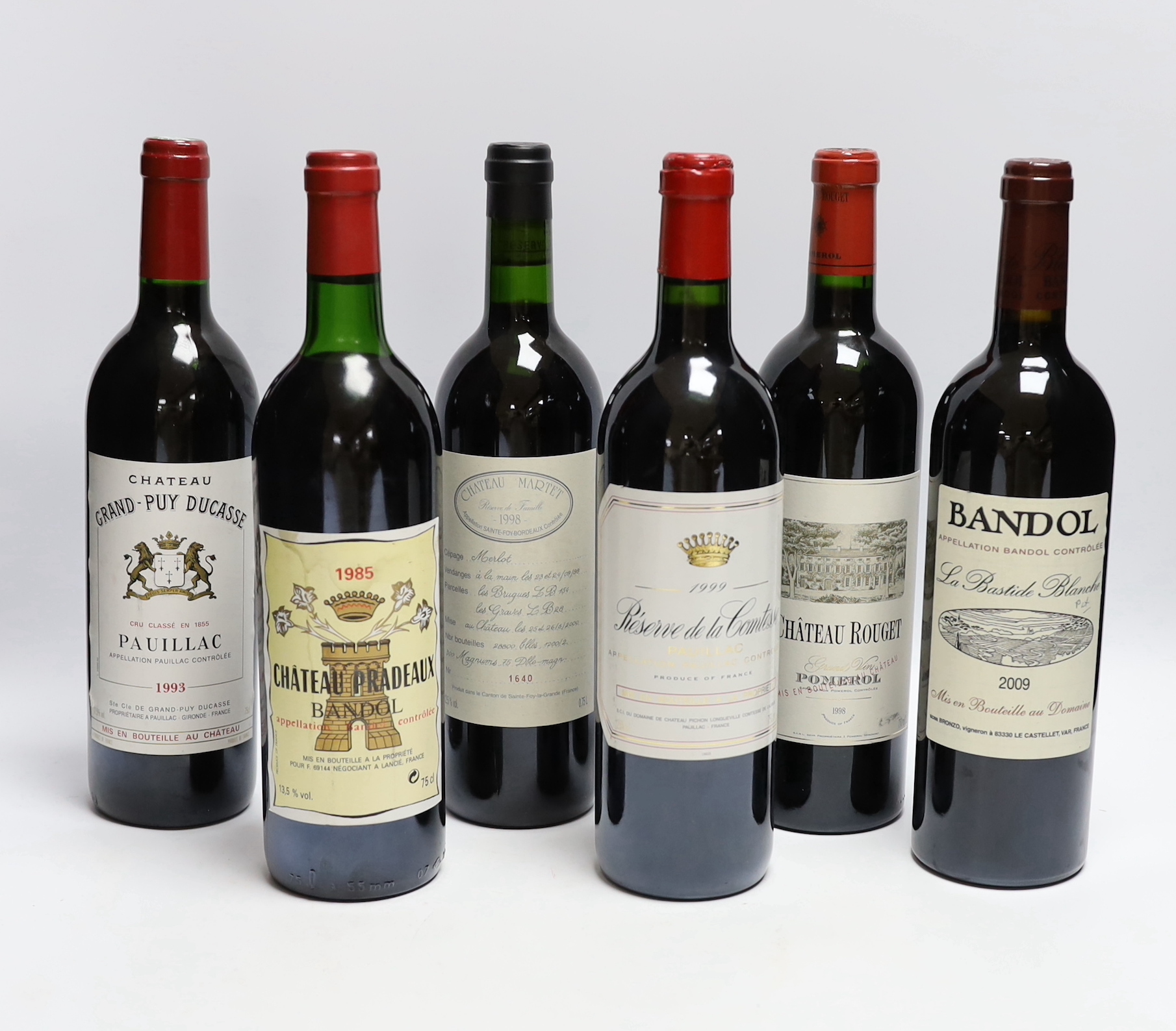 Six bottles of wine - 1998 Chateau Rouget Pomerol, 1999 Reserve De La Comtesse Pauillac, 2009 Bandol La Bastide Blanche, 1985 Chateau Pradeaux Bandol, 1998 Chateau Martet and 1993 Chateau Grand Puy Ducasse Pauillac